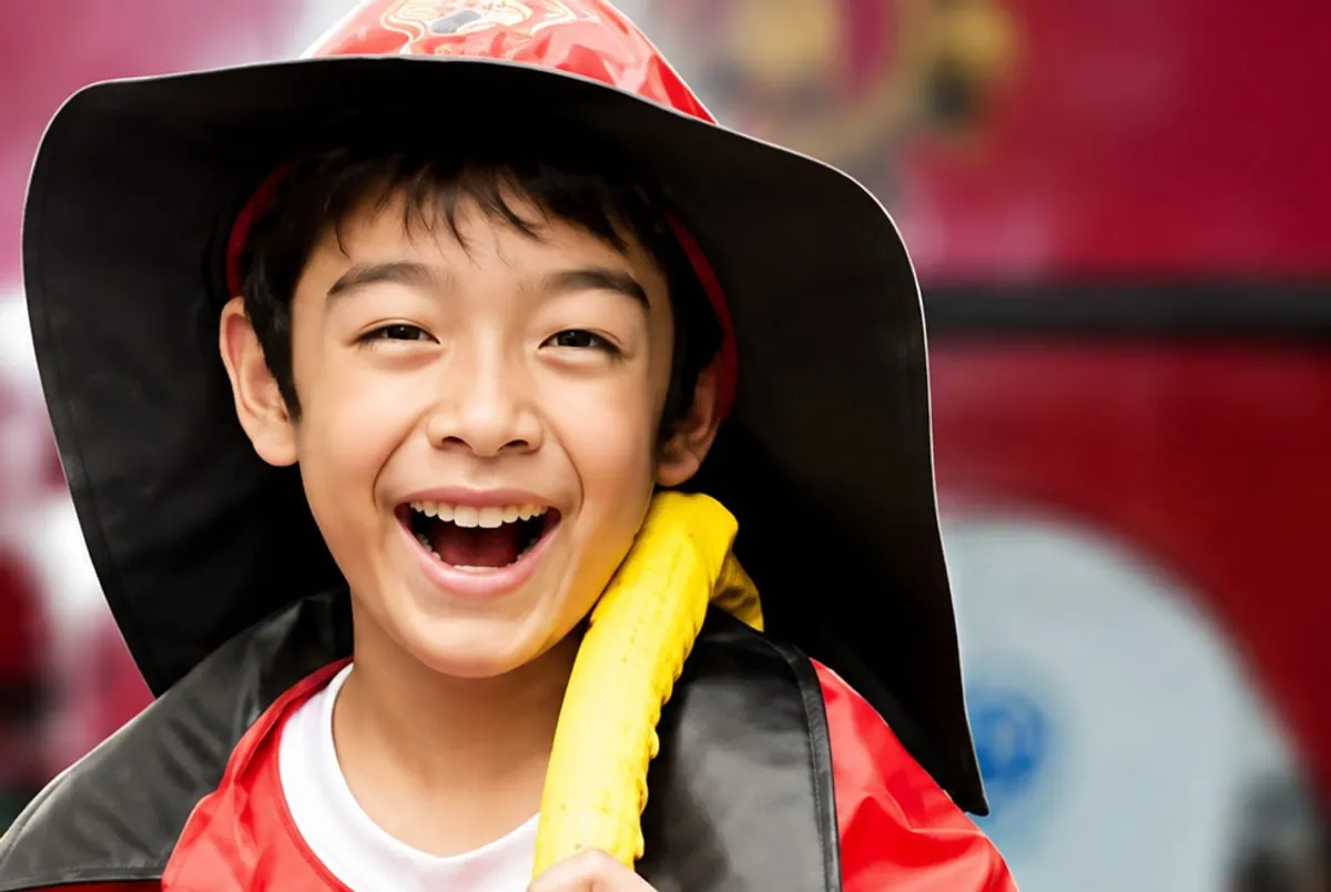 Smiling child in a fire helmet during a kids' fire safety education session